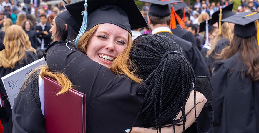 毕业后，学生们戴着学士帽和学士服互相拥抱